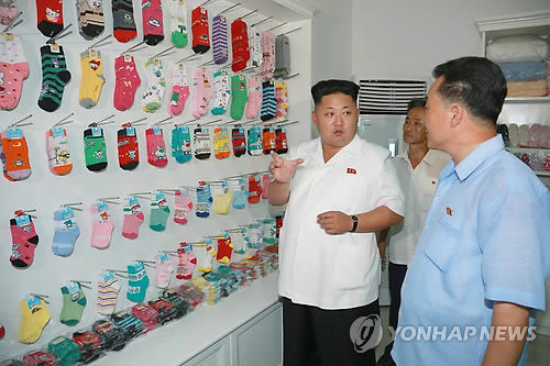 金正恩去年7月视察平壤袜厂时的照片。（韩联社）