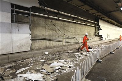 大屯路隧道内，北侧约70平米墙皮被剐蹭掉，救援人员正在清理。新京报记者 浦峰 摄