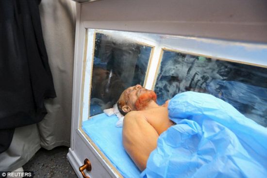 图为萨达姆前亲信尸体被装进玻璃棺。