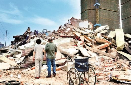 武汉市�口区建荣村一家民营医院被强拆。昨日上午，女院长在亲属搀扶下回到现场，看到的只有一片废墟。 楚天都市报记者黄士峰摄