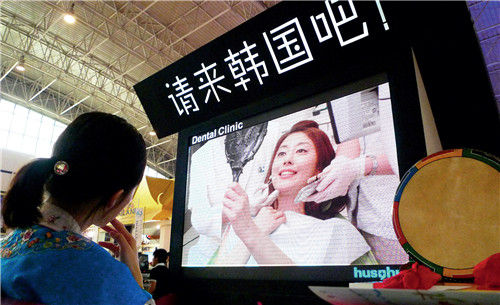  韩国旅游发展局在2010年北京国际旅游博览会上播放韩国整形宣传片。CFP