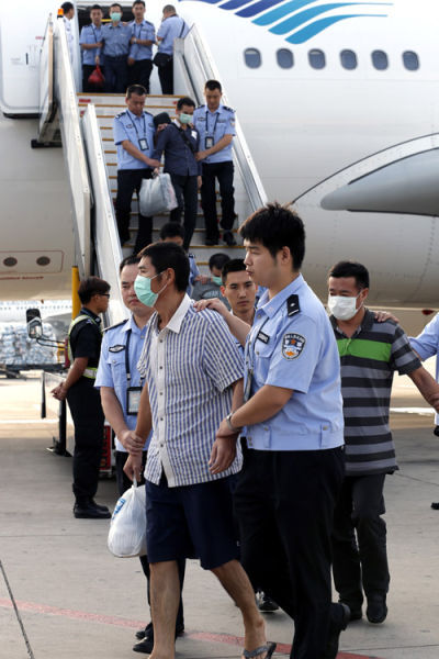 6月21日，公安人员在北京首都机场押解经济犯罪嫌疑人走下飞机。