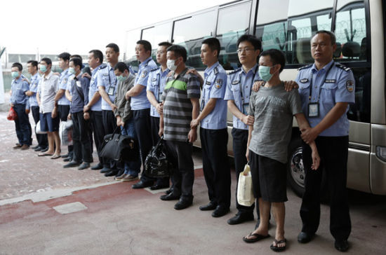 6月21日，公安人员在北京首都机场押解6名境外在逃经济犯罪嫌疑人。