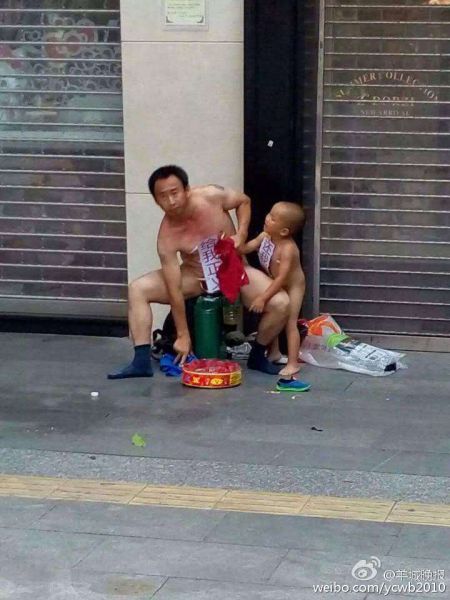 闹事男子带儿子全裸坐在商店门口，地上摆放一卷鞭炮