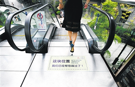 重庆市渝中区重庆天地,扶梯的第二块踏板贴上“帮您踩过”的标示。 记者 吴珊 摄 重庆市渝中区重庆天地,扶梯的第二块踏板贴上“帮您踩过”的标示。 记者 吴珊 摄