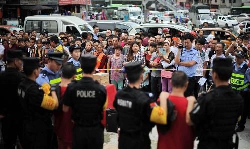 身着鲜红色囚服、拖着沉重的脚镣，7名盗抢嫌犯日前在特警的押解下，到贵阳闹市指认现场，引发群众围观。