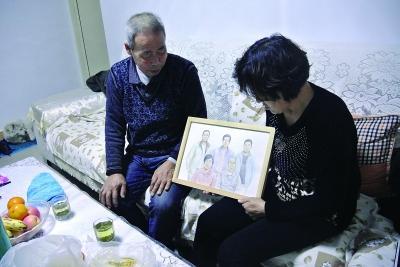 呼格吉勒图的父母向记者展示全家福画像，呼格吉勒图也在画像中