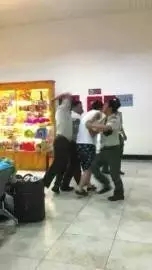 　越南边检人员将一名中国男游客抓住，一名边检人员还有肘击其背部的动作。