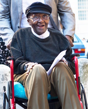 Desmond Tutu arrives in a wheelchair to celebrate his 85th birthday at St George