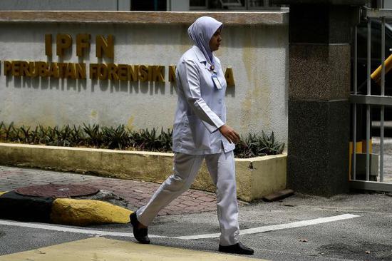 2月24日，在马来西亚吉隆坡，一名护士经过停放死亡朝鲜男子遗体的医院。新华社/法新