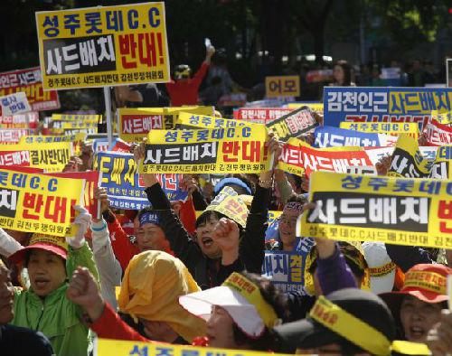 资料图片：韩国民众集会高举标语反对部署“萨德”系统。（新华社）