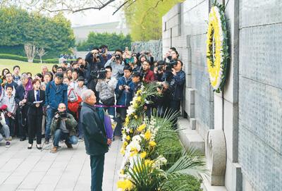 4月4日，南京大屠杀幸存者及遇难者遗属代表50余人，在侵华日军南京大屠杀遇难同胞纪念馆内的遇难者名单墙前举行清明家祭活动，祭奠被侵华日军杀害的亲人。来自日本的友人、澳大利亚青年代表等一同参加了祭奠活动。图为幸存者岑洪桂在为遇难亲人献花。新华社记者 韩瑜庆摄