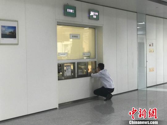 图为患者蹲着与医生进行交流。　梅镱泷 摄