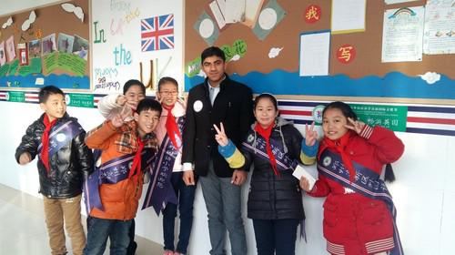 纳西姆在中国期间参加志愿者活动，与小学生合影留念。