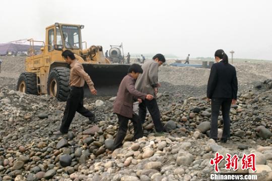 2005年彭山岷江一河滩工地挖出银锭后，当地一些村民在河滩上寻宝。（资料图） 刘忠俊 摄