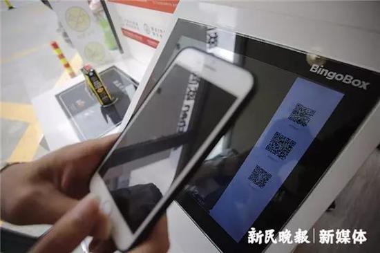 图说：扫码付费。萧君玮/摄