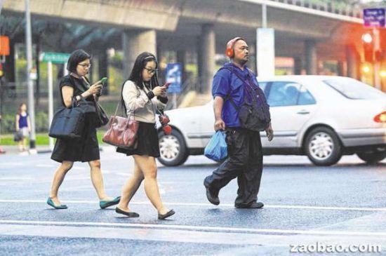 世界上多国都存在着行人过马路时看手机的现场（图为新加坡街头）