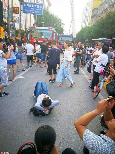 “看热闹不怕事大”有市民躺在马路上观看。