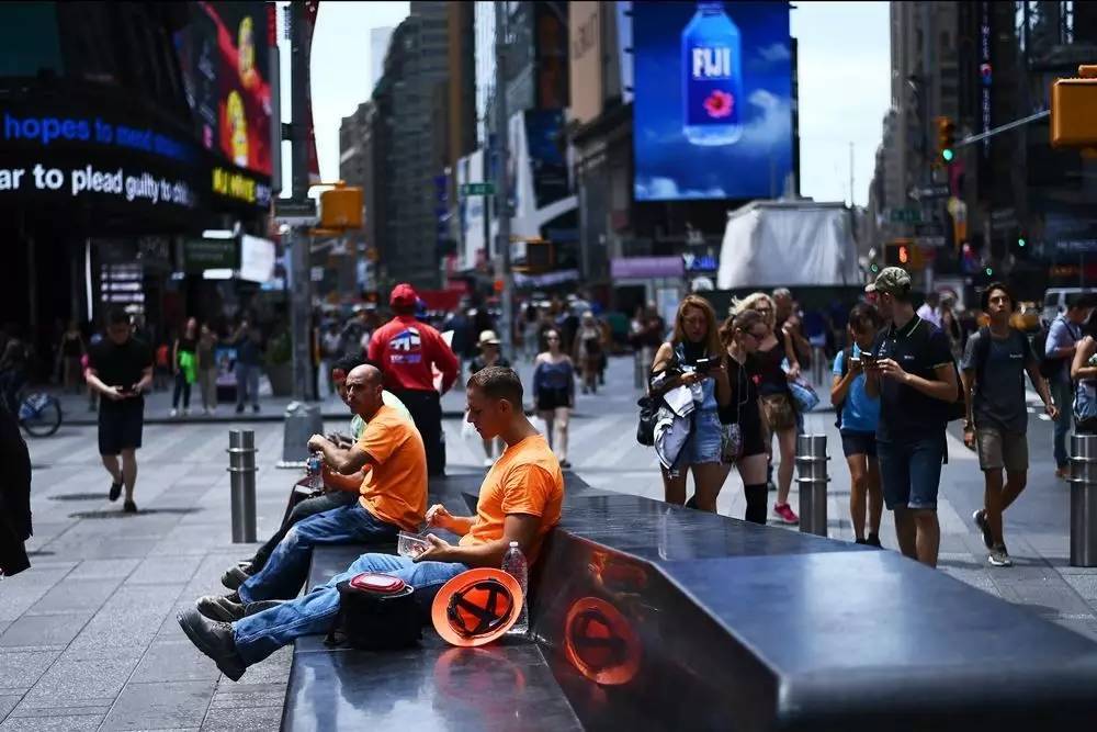 ▲资料图片：7月10日，几名工人在纽约时报广场午休。（法新社）