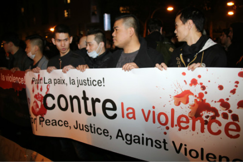 资料图：面对一桩桩袭击华人案件，旅法华人举出“为了和平，为了公正，反暴力”的标语。图为华人举标游行。（法国《欧洲时报》/梁家铭 摄）