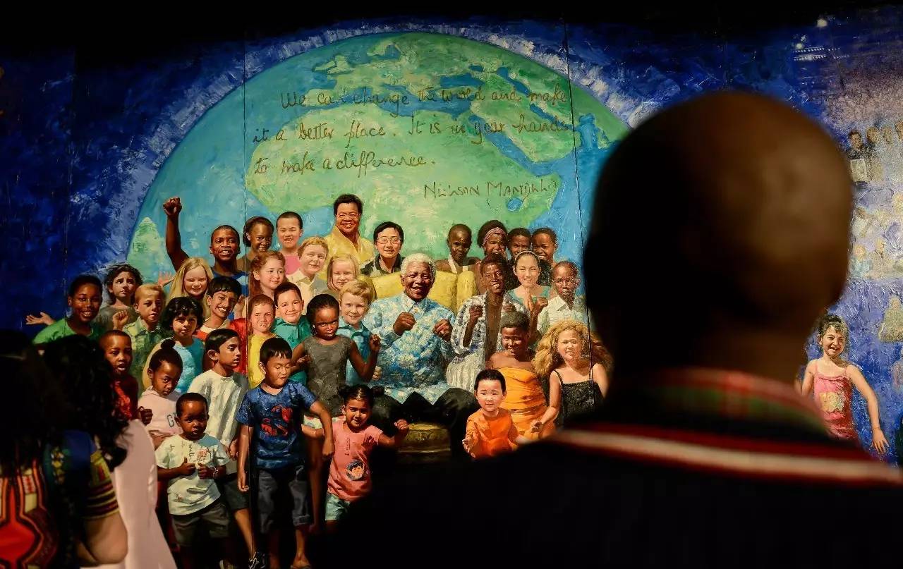 　▲资料图片：2015年4月21日，一名观众在南非约翰内斯堡大学欣赏中国艺术家李斌耗时两年创作的长卷史诗油画《曼德拉》。此次展览由约翰内斯堡大学及该校孔子学院共同举办。