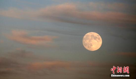 资料图：一轮圆月高挂天边，在晚霞的映衬下下十分俏丽。 中新社发 卜向东 摄 图片来源：CNSPHOTO