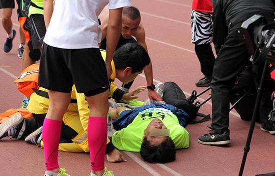 2016年10月30日，上海国际马拉松赛，一位跑者过终点线后倒地昏迷，紧急救治后苏醒，周围运动员纷纷为他和医务人员鼓掌加油。东方IC 资料图