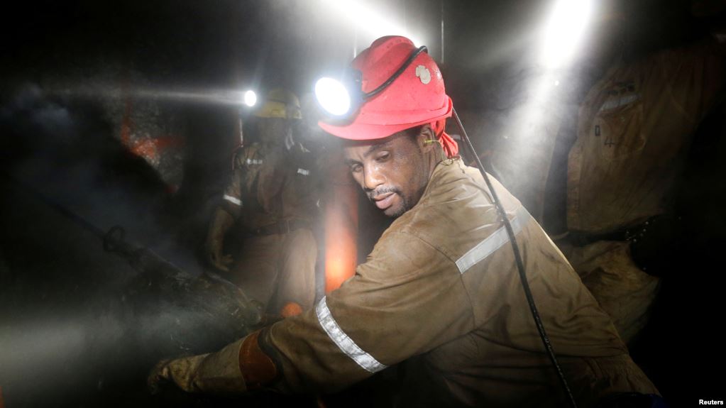 FILE - Miners work deep underground at Sibanye Gold's Masimthembe shaft in Westonaria, South Africa, April 3, 2017.