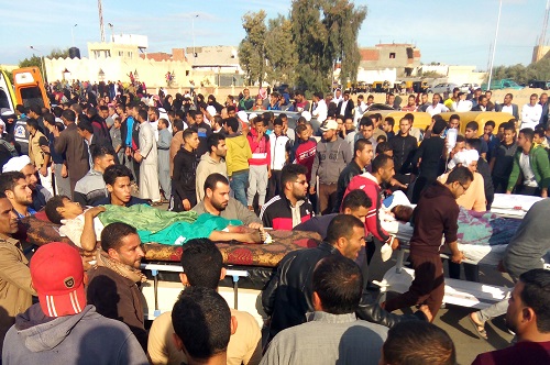 24日，埃及民众在清真寺遇袭后用担架运送伤员。（法新社）