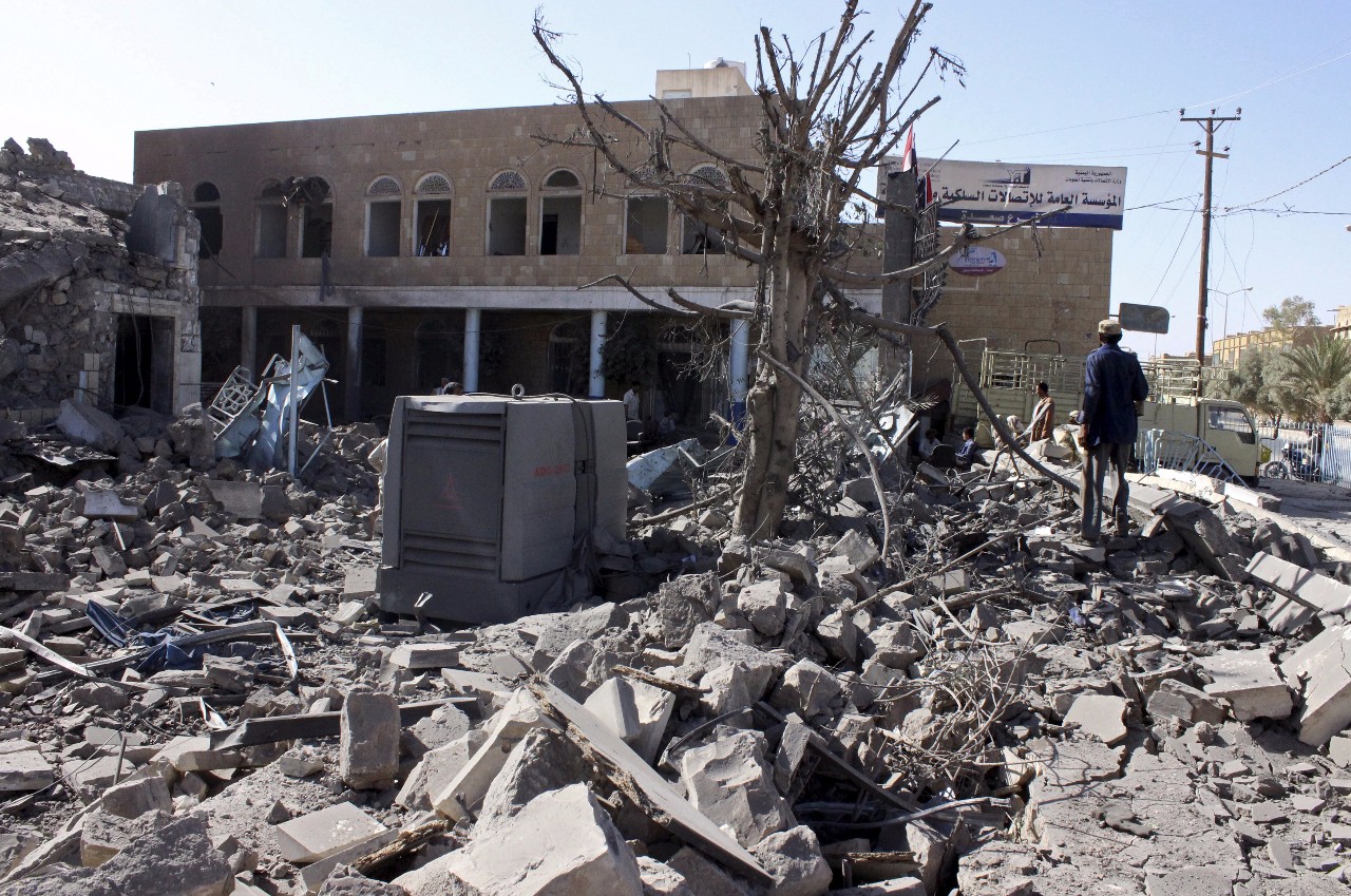图为2015年4月22日，人们在也门西北部城市萨达查看一处空袭现场。