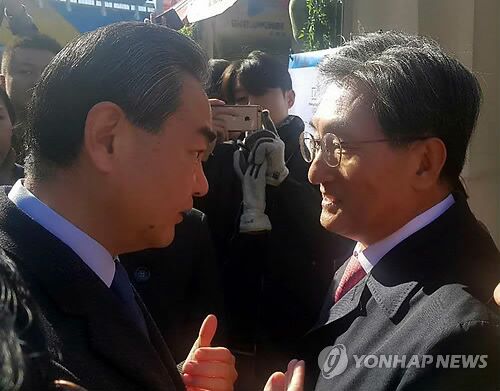  中国外交部长王毅（左）同韩国驻华大使卢英敏交谈（韩联社）