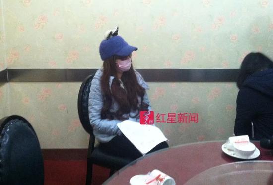 ▲庭审结束后，赵某戴着帽子和口罩接受媒体采访