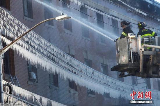 当地时间2018年1月2日，美国纽约，消防员对抗布朗克斯区的大火。火灾发生在寒冷的凌晨，消防部门喷水带来了“冰封世界”。