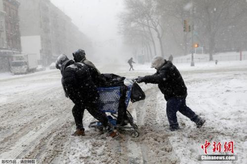  图为曼哈顿“上城区”的居民在暴雪中艰难出行。