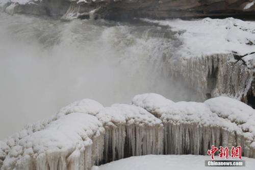  陕西延安黄河壶口瀑布一片银装素裹，瀑布两岸被积雪覆盖。梁鹏 摄