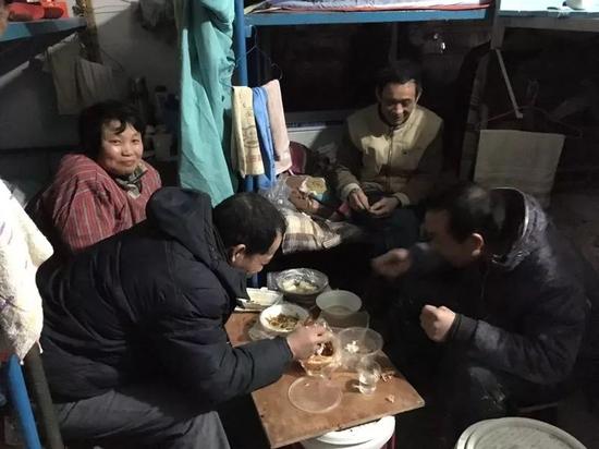 工友们正在吃晚饭，图片左边为一对打工者夫妇。新京报记者罗芊 摄