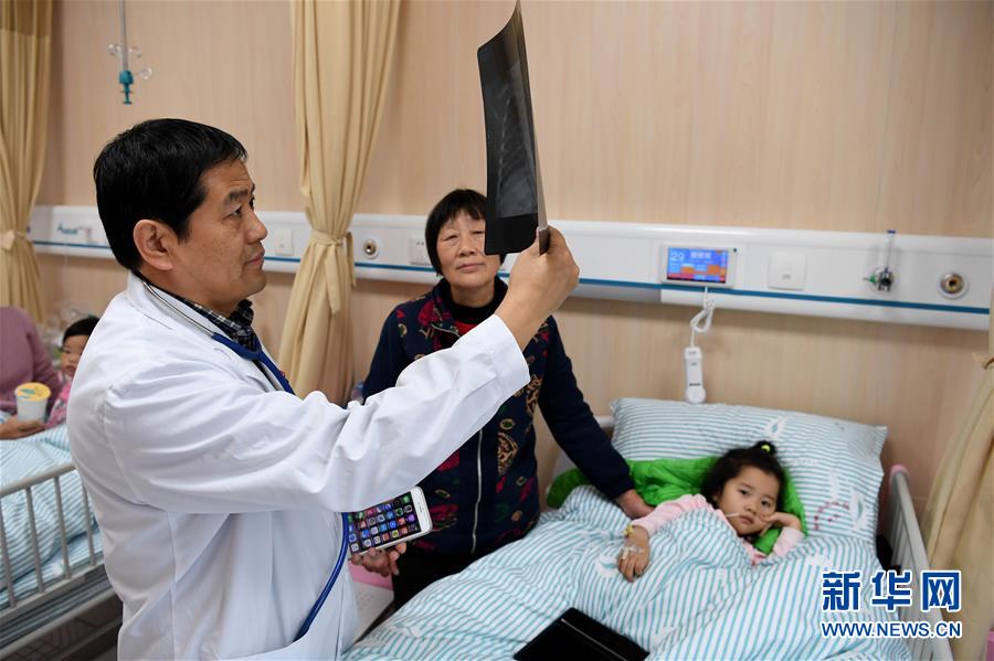 在安徽省立医院南区儿科病房，儿科副主任医师朱守法在给小患者诊治（12月6日摄）。新华社记者 刘军喜 摄