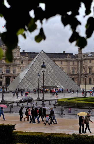 资料图片：2014年5月1日，游客冒雨在巴黎卢浮宫参观。新华社记者 陈晓伟 摄