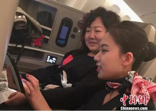 空乘人员指导乘客连接机上Wifi。图片来源 <a target='_blank' href='http://www.chinanews.com/' _fcksavedurl='http://www.chinanews.com/' >中新网</a>
