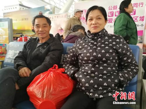 程助华夫妇在广州南站接受记者采访。 中新网记者 张尼 摄