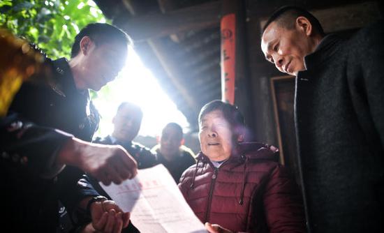 1月21日，在四川泸县方洞镇，民警为艾秀平和儿子杨荣宣读《被拐儿童身份确认通知书》。 新华社记者薛玉斌摄