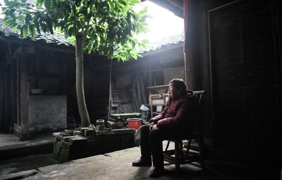 1月21日，在四川泸县方洞镇，86岁的艾秀平坐在堂屋的竹椅上，痴痴地向门外张望，等待儿子回家。 新华社记者薛玉斌摄