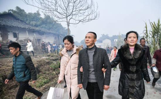 1月21日，在四川泸县方洞镇，杨荣（右二）在妻子和女儿的陪伴下从内江回到泸县“认祖归宗”。新华社记者薛玉斌摄