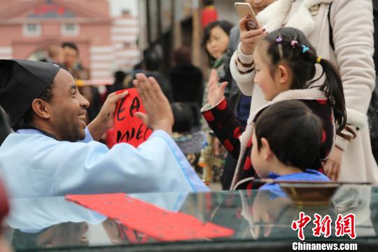 图为外籍友人送小朋友新春祝福。　杨孝勇　摄