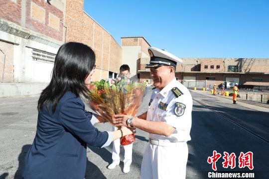 迎接的华人华侨为编队指挥员献花。 刘鑫 摄