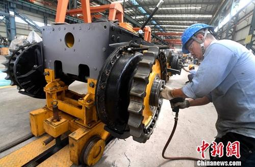 图为厦工（三明）重型机器有限公司工人在生产线上作业。（资料图片）中新社记者 张斌 摄