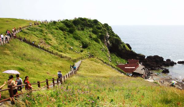 资料图：游客游览韩国济州岛著名景点日出峰。新华社记者姚琪琳摄