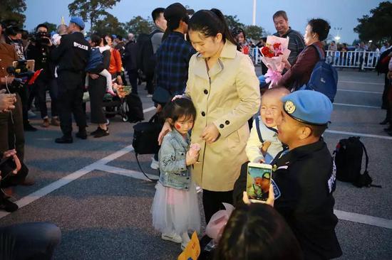 （2018年3月1日，南宁国际机场，秦宗润第一次亲眼见到9个月的儿子，而5岁的女儿也远远躲着他。陈志荣/摄）
