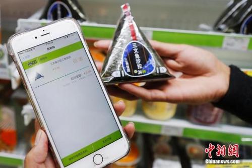 近年，移动支付在中国逐渐流行。图为顾客扫描商品条形码手机自助结账。 殷立勤 摄