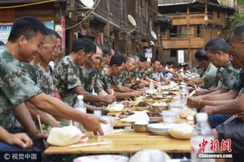 资料图：贵州从江县谷坪乡邀请复员退伍军人、现役军人家属等，摆上长桌宴，庆建军90周年。吴德军 摄 图片来源：视觉中国